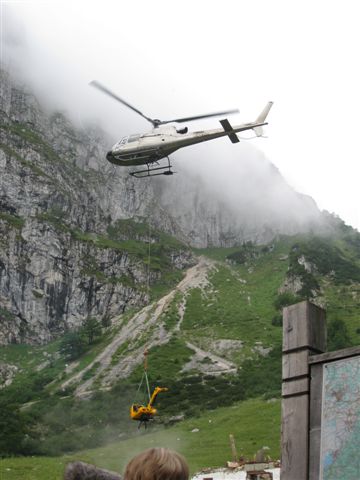 Hubschrauber fliegt Bagger ein